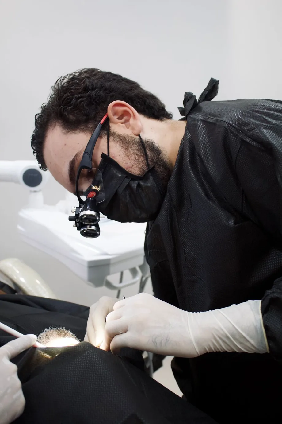 Dr. Gabriel Pagliarini realizando procedimento com lupas